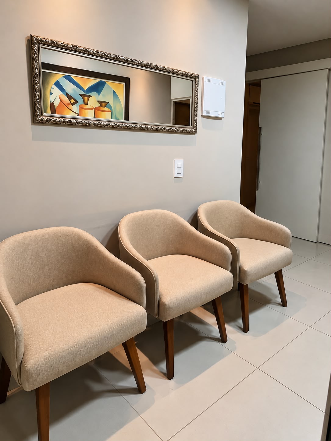 Poltronas claras junto ao espelho e à decoração botânica.