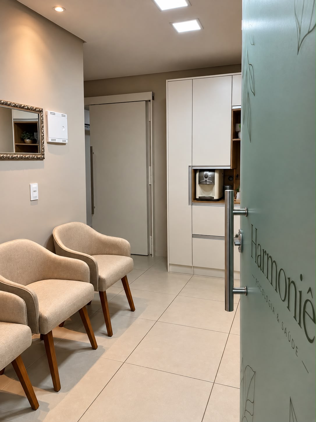 Entrada do consultório com porta de vidro e poltronas.